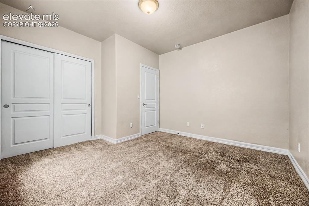 Image 23 of 44: Fourth bedroom is located in the basement and includes a nearby full bathro