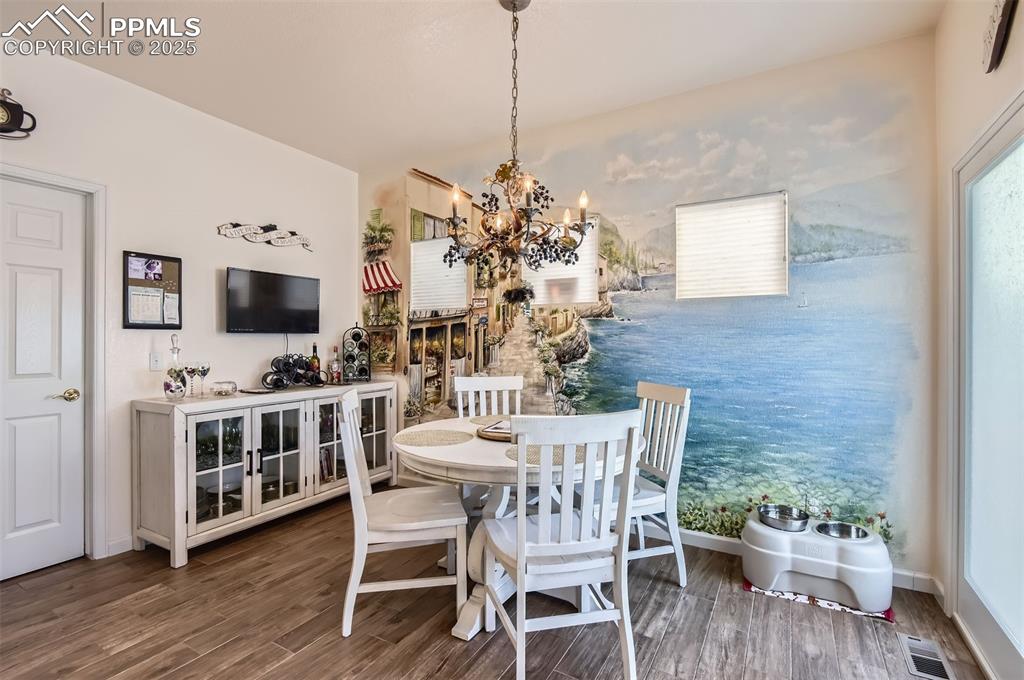 Image 13 of 28: Dining space featuring an inviting chandelier and hardwood / wood-style flo
