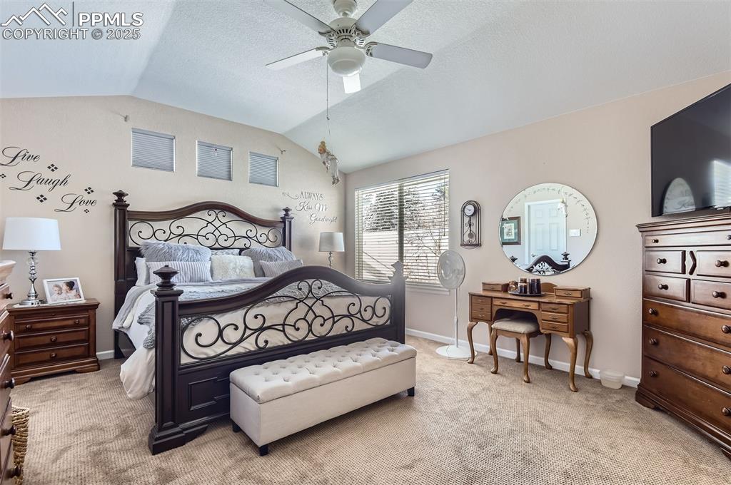 Image 16 of 28: Bedroom with a textured ceiling, ceiling fan, light carpet, and lofted ceil