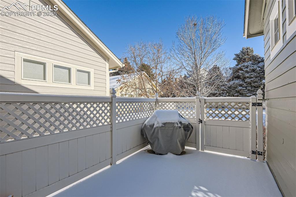 Image 28 of 28: Snow covered patio with a grill