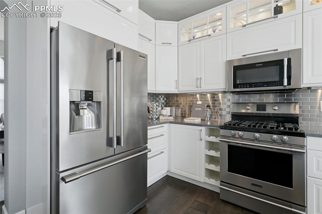 Image 12 of 50: Lighted upper cabinets, beverage storage, beautiful stainless appliances!