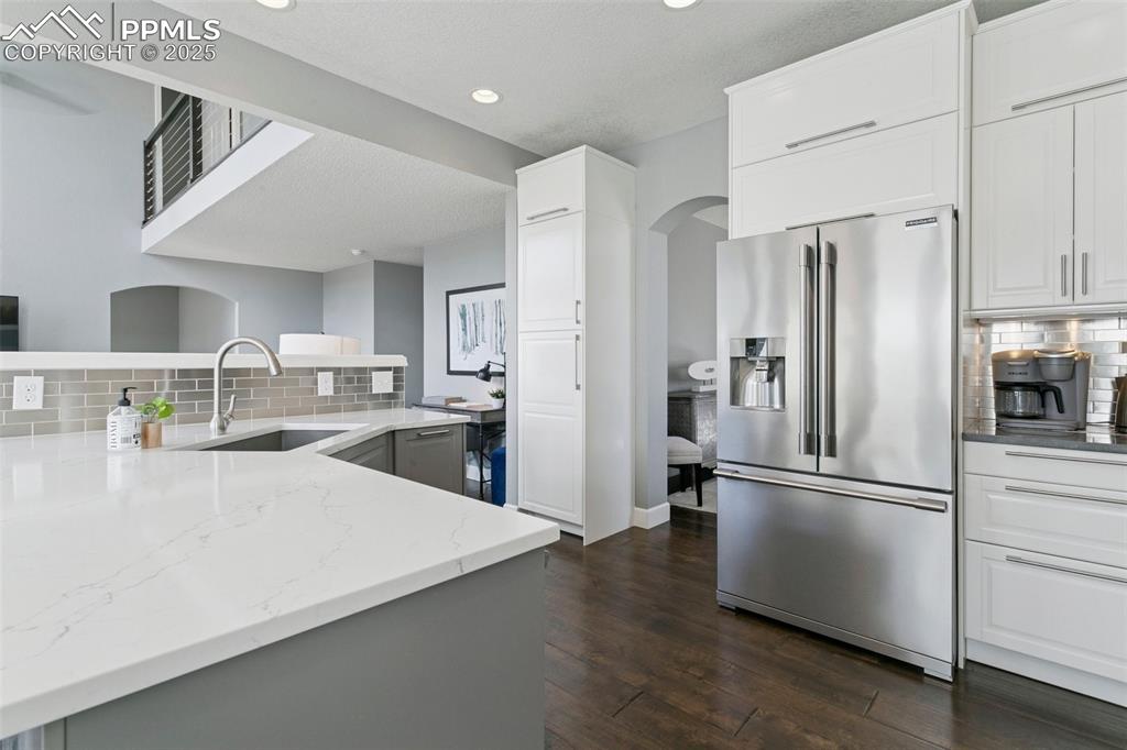 Image 14 of 50: Large storage cabinets above the refrigerator and a view of one of the two 