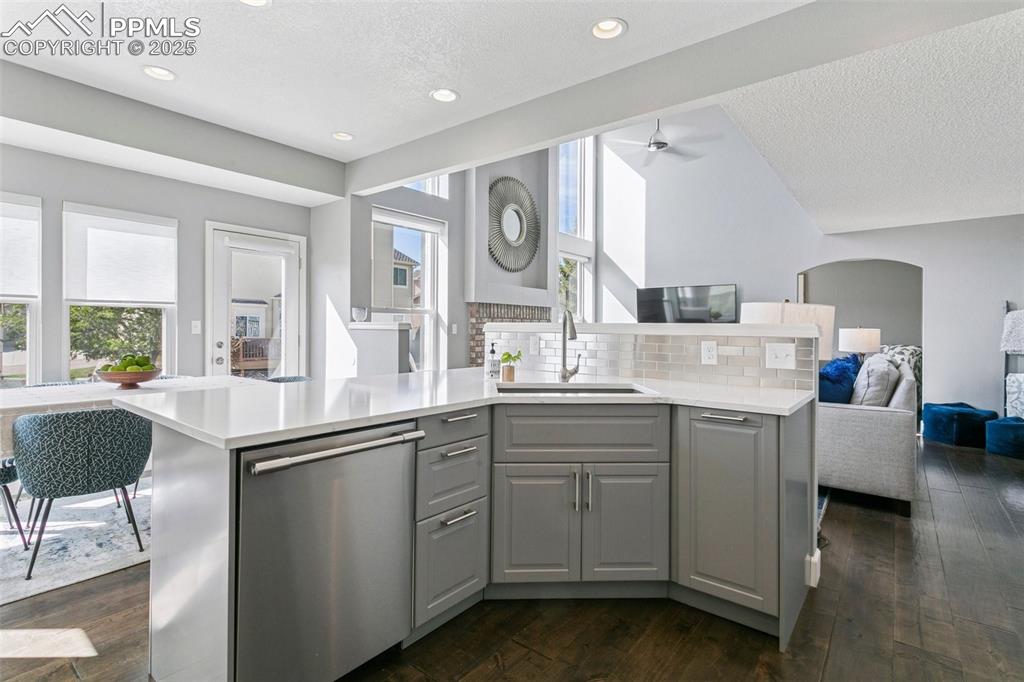 Image 15 of 50: Large kitchen island w/quartz counters, farmhouse sink and a stainless stee