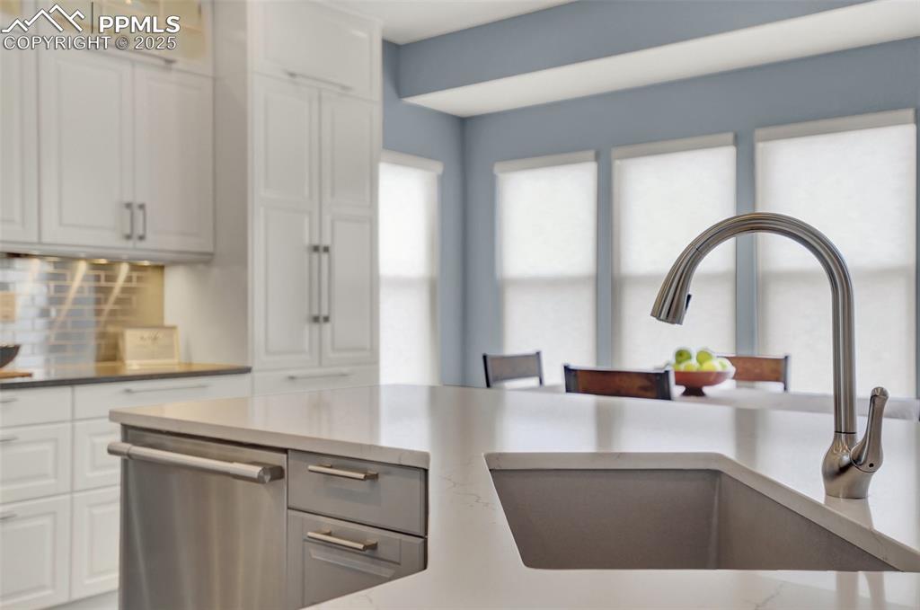 Image 16 of 50: Custom granite farmhouse sink at the kitchen island