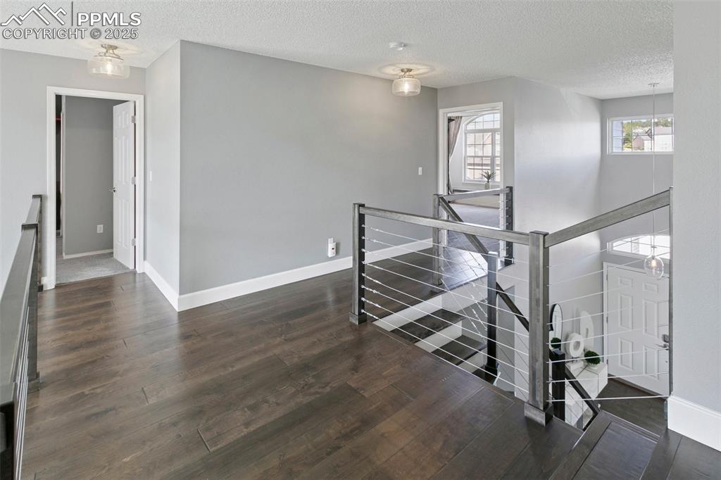 Image 27 of 50: Upper-level landing opens to both the front and the back of the home.