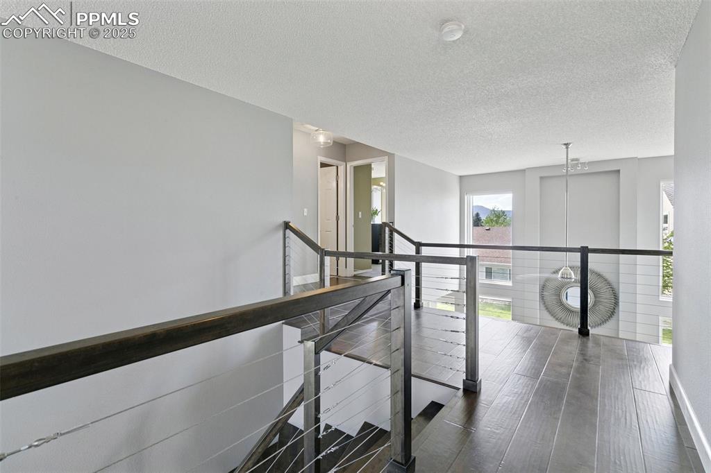 Image 28 of 50: The landing features engineered birch floors, custom birch railings and met