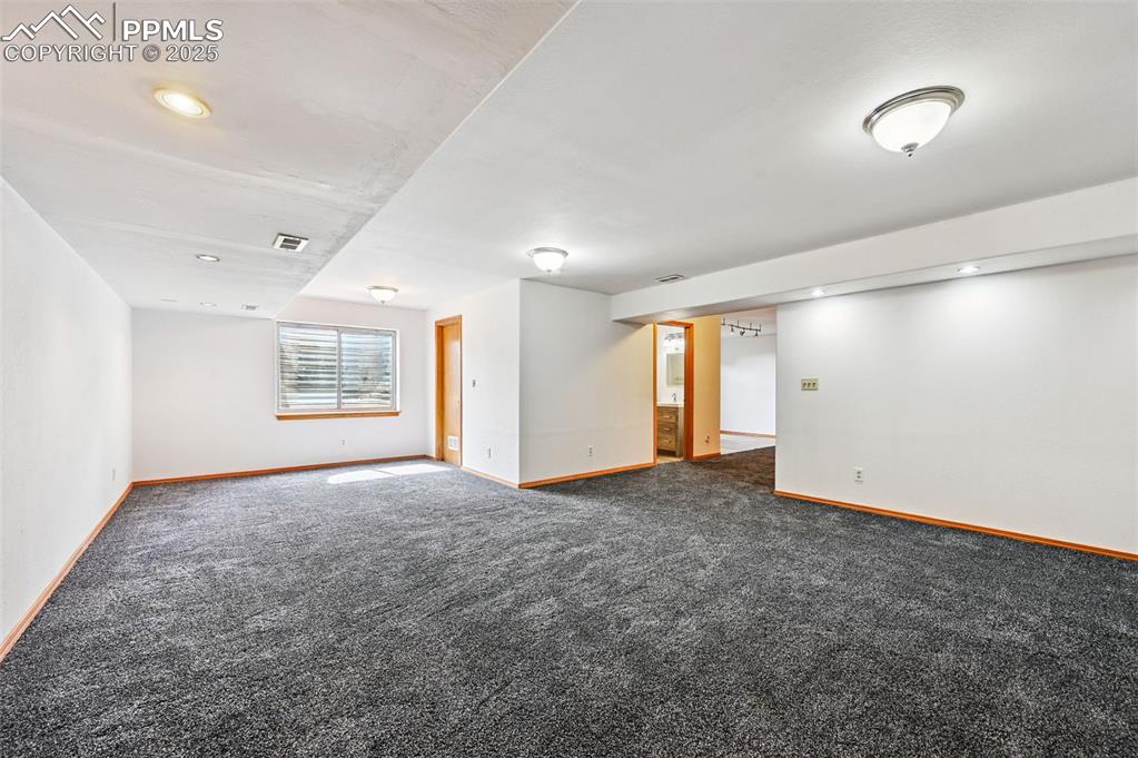 Image 33 of 50: Spare room featuring dark colored carpet and recessed lighting
