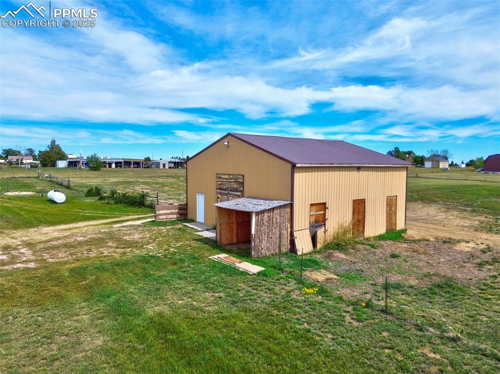 Image 44 of 50: View of pole building with a yard and a view of rural / pastoral area