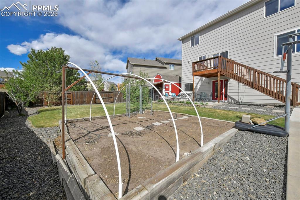 Image 35 of 46: Raised garden bed with a hoop frame and featuring a pathway
