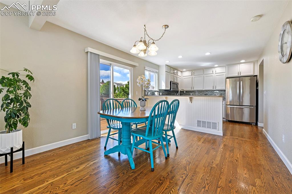 Image 8 of 46: Open and inviting dining room with sliding glass door to the deck