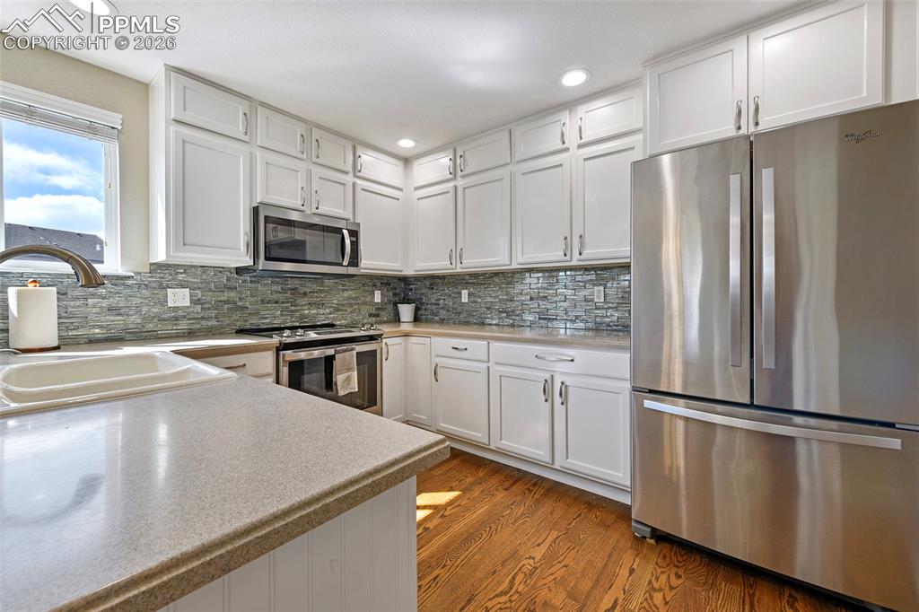 Image 9 of 46: Floor to ceiling cabinetry, corian countertops and stainless steel applianc