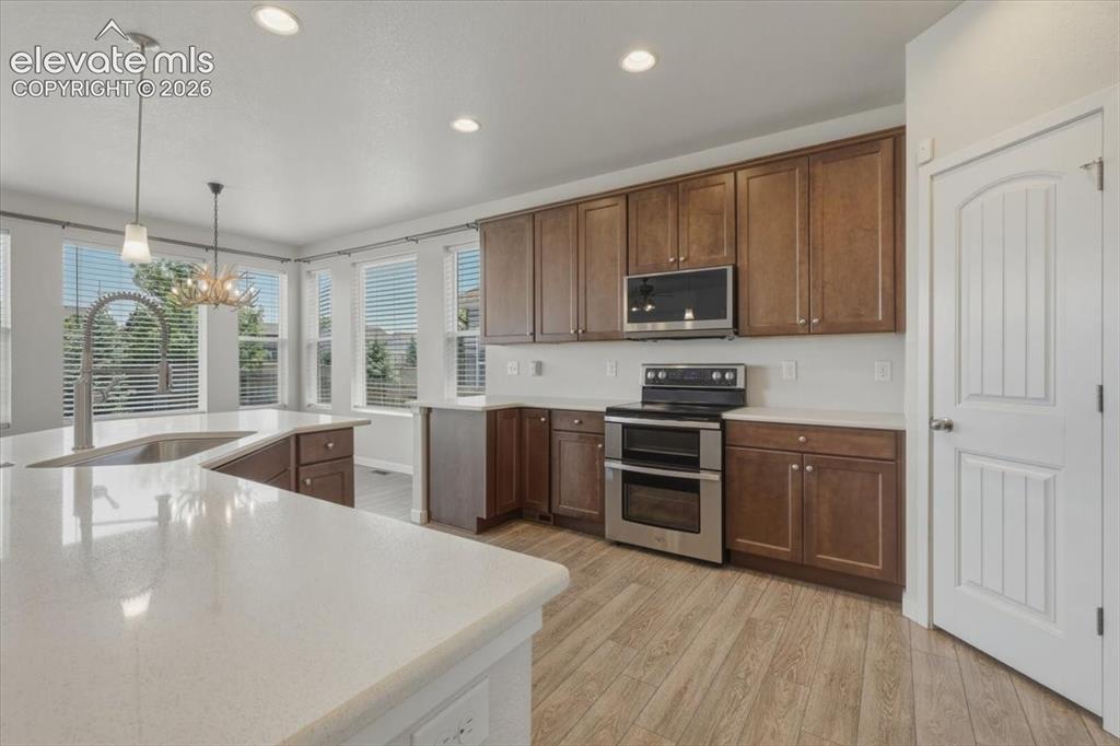 Image 10 of 50: Open-concept kitchen featuring an expansive island with a stainless steel s