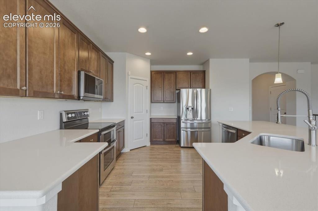 Image 12 of 50: Kitchen featuring wood-finish flooring, recessed lighting, and an arched do