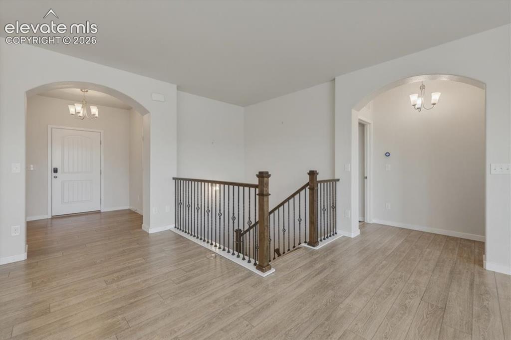 Image 18 of 50: Wood-finish flooring throughout, arched doorway, ceiling fan with integrate