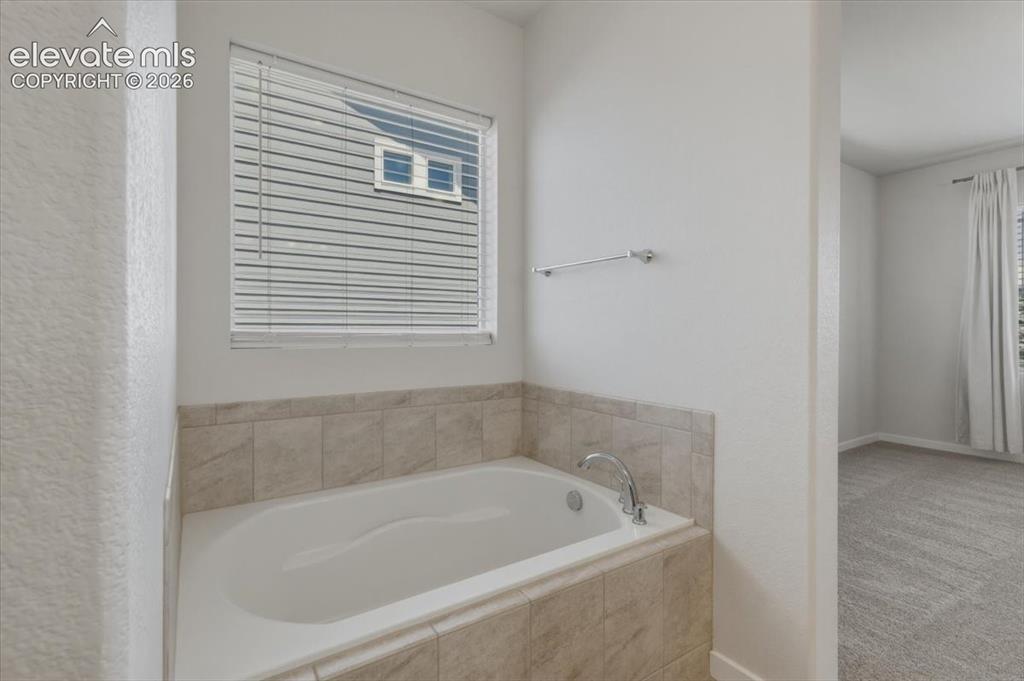 Image 24 of 50: Spacious carpeted room featuring a ceiling fan with integrated lighting, a