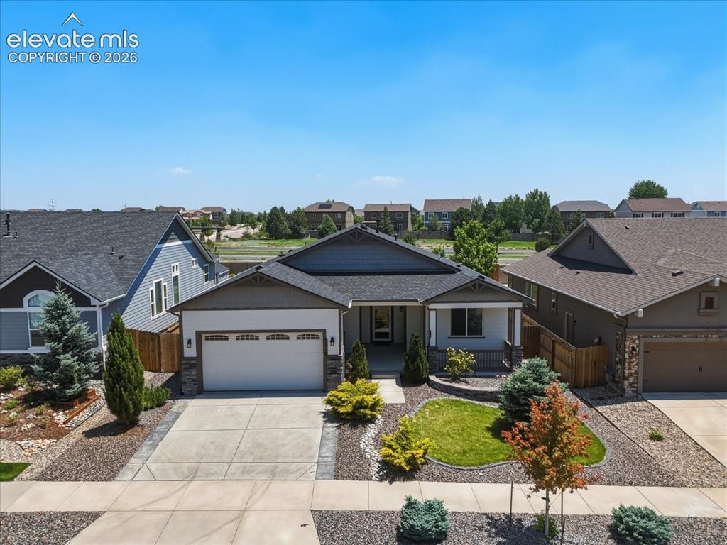 Image 3 of 50: Single-story residence featuring a two-car garage, covered porch, and a com