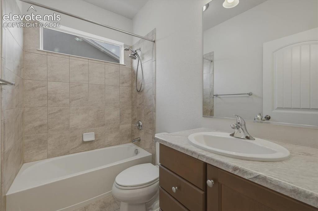 Image 5 of 50: Bathroom featuring a full tub with shower, tiled surround, and transom wind