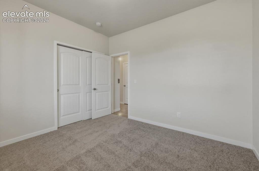 Image 7 of 50: Carpeted interior room featuring light-colored walls and white trim