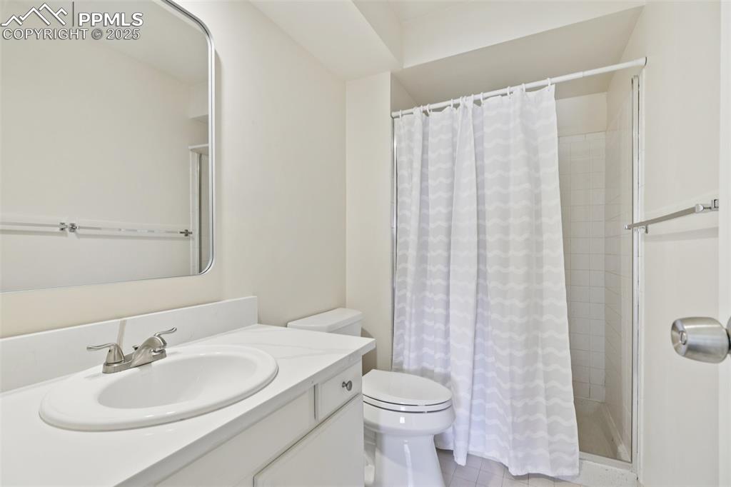 Image 19 of 25: Full bathroom featuring vanity, tiled shower, and tile patterned flooring