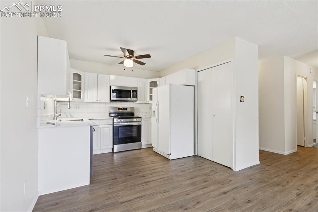Image 4 of 25: Kitchen featuring stainless steel appliances, ceiling fan, backsplash, and