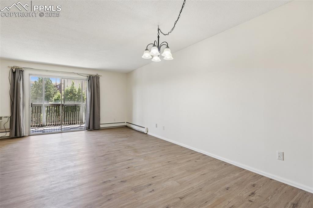 Image 6 of 25: Unfurnished room featuring a chandelier and wood finished floors