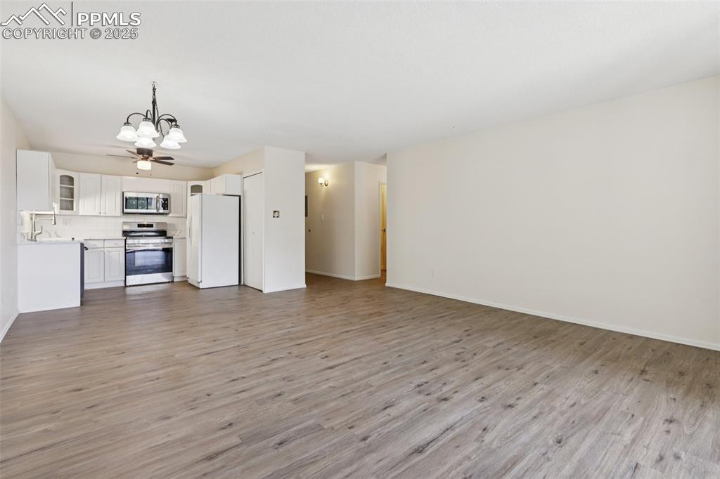 Image 9 of 25: Unfurnished living room featuring a chandelier and light wood-type flooring