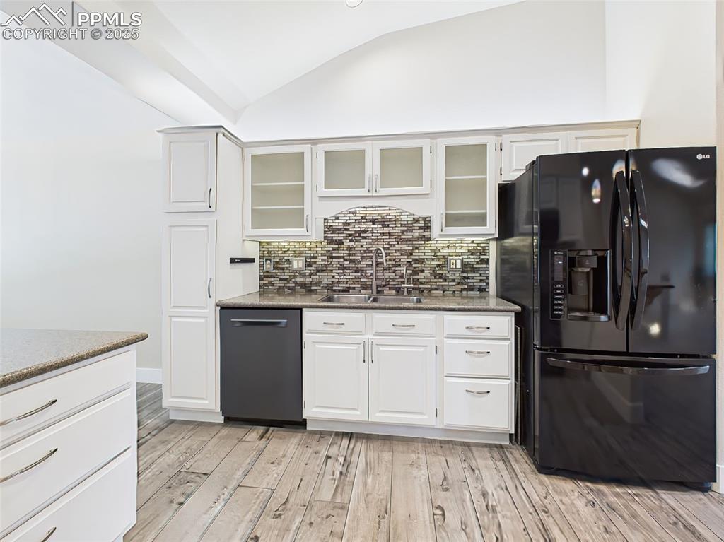 Image 13 of 50: White pantry cabinet to left of sink has pull-outs! Beautiful glass tile ba