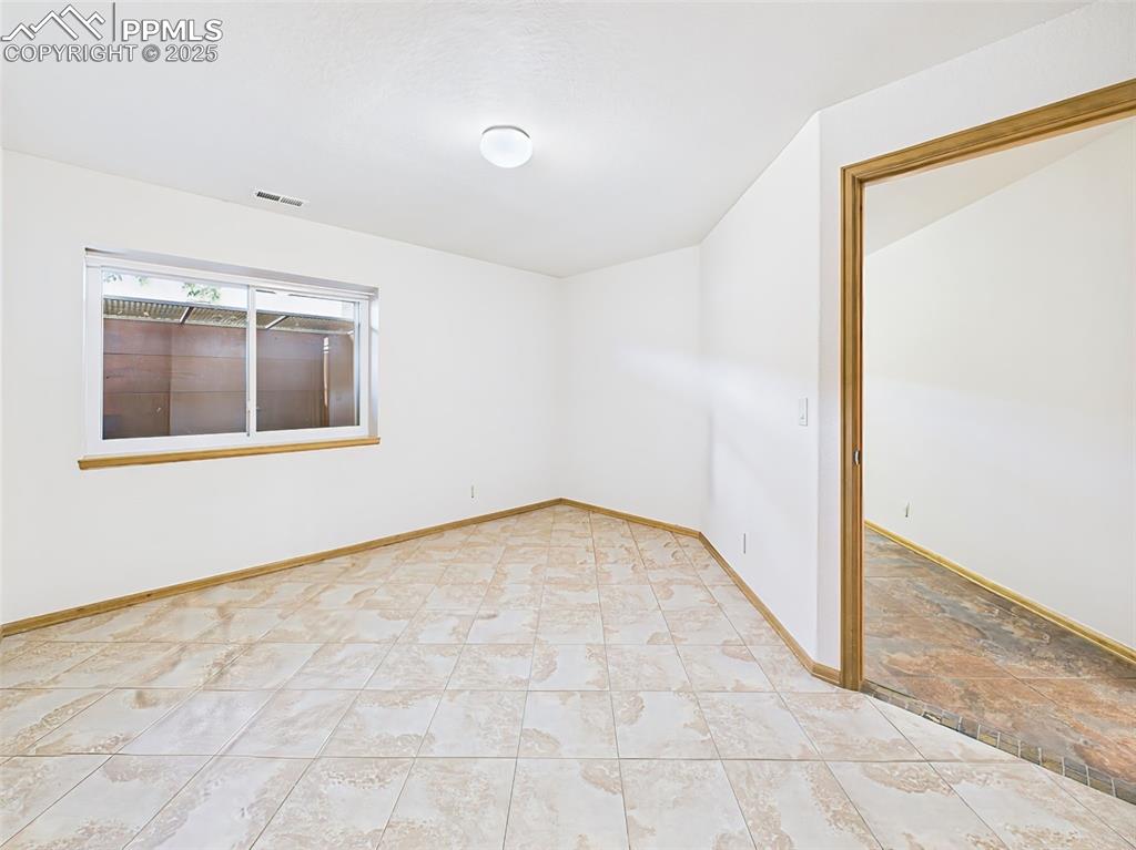 Image 40 of 50: Bedroom #2 in basement has garden level window and tiled floors!