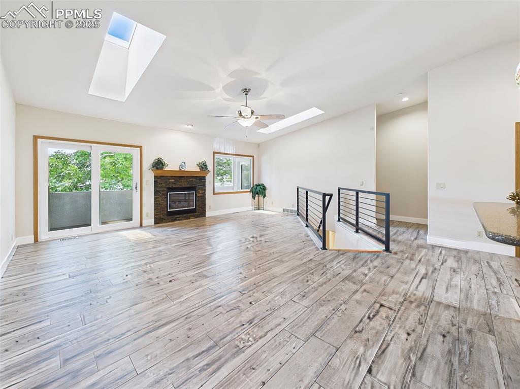 Image 7 of 50: Newer flooring, modern metal handrails, custom stacked stone fireplace, wal