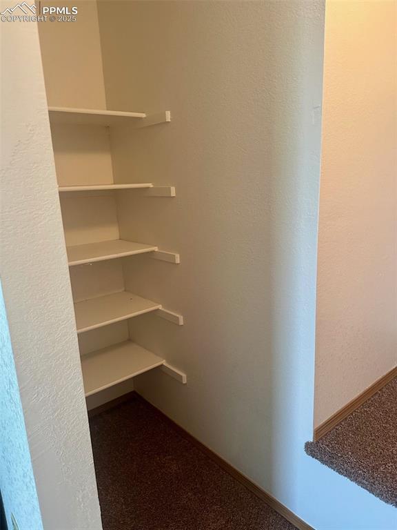 Image 19 of 39: Built in shelving in primary bedroom closet.