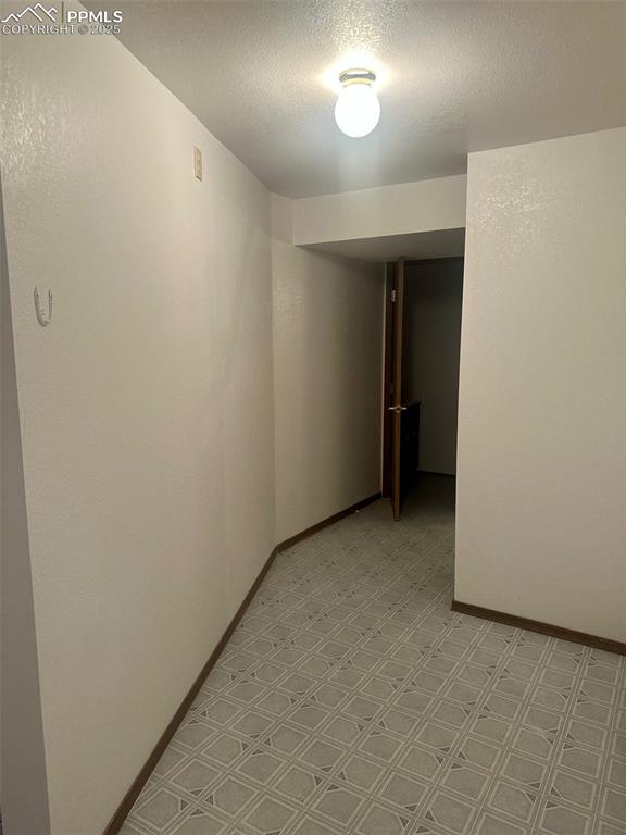 Image 29 of 39: Hall leading to basement level 3/4 bath, mechanical & laundry area.