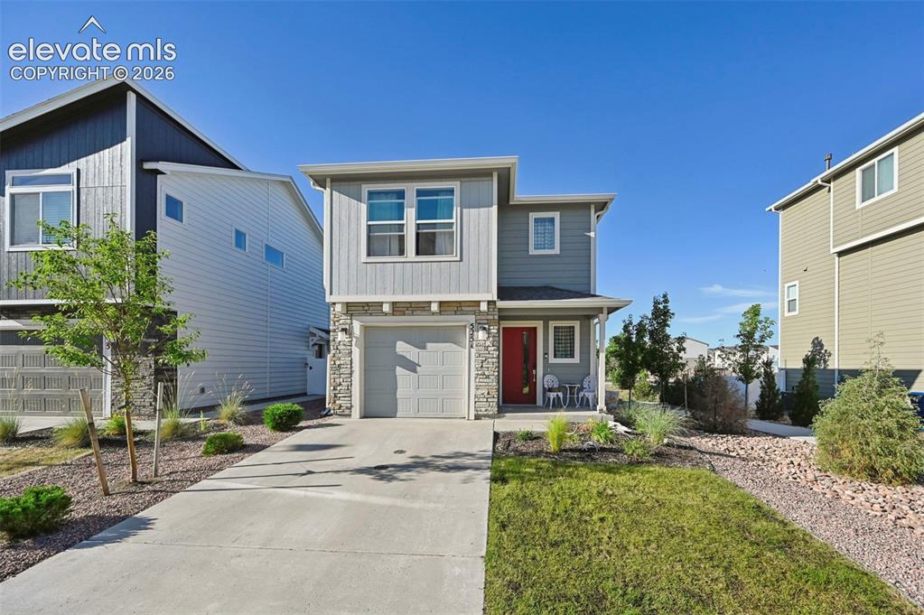 Image 1 of 30: Contemporary two-story exterior featuring a single-car garage and a vibrant