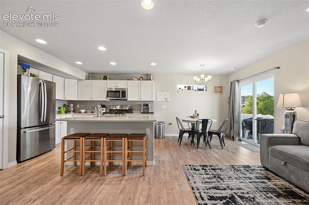 Image 14 of 30: Open-concept living space with wood-finish flooring