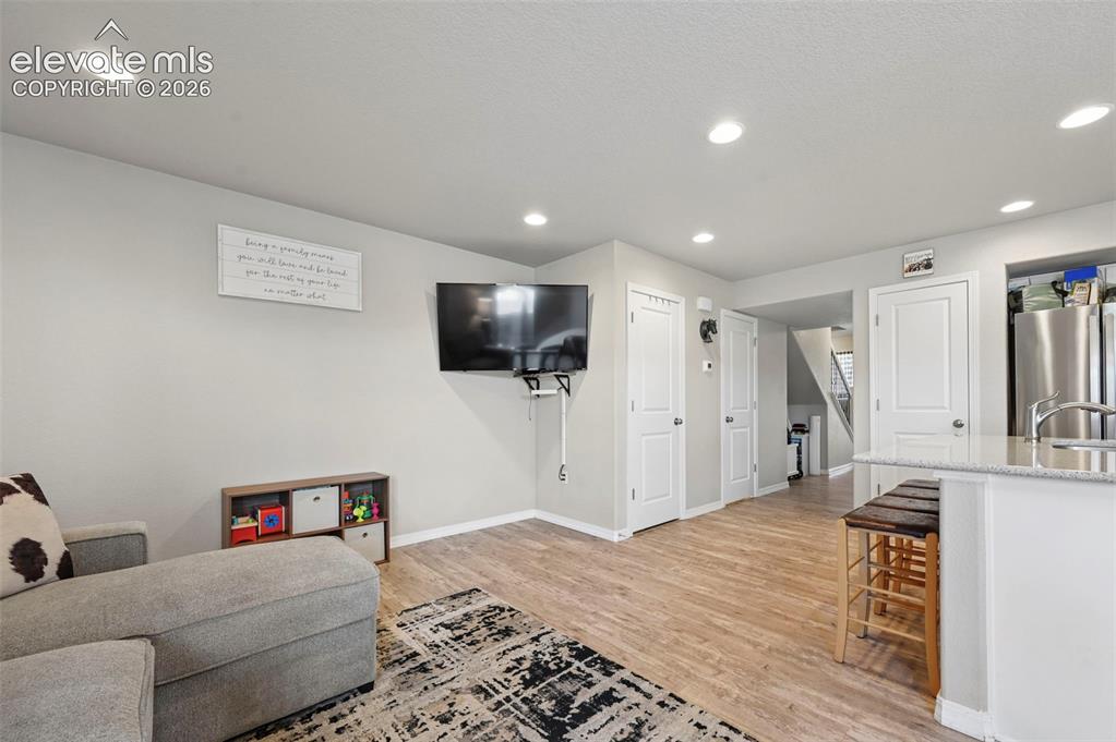 Image 17 of 30: Open-concept living area featuring wood-finish flooring, recessed lighting,