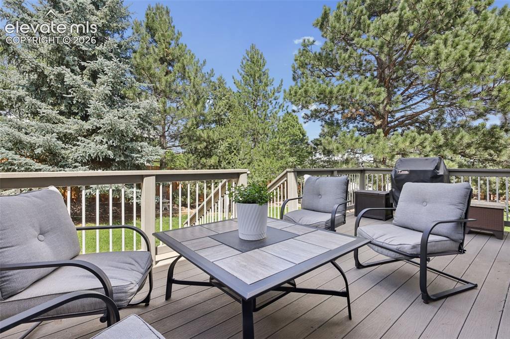 Image 25 of 27: Rear yard deck with mature trees for added privacy