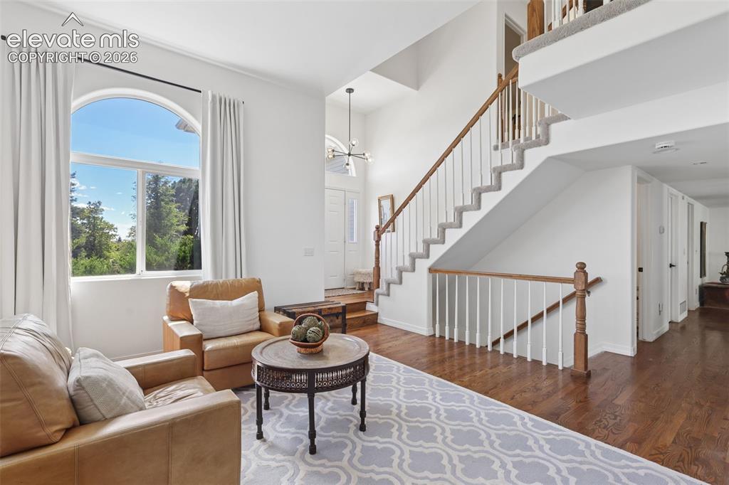 Image 7 of 27: Formal living room with vaulted ceiling and hardwood floors