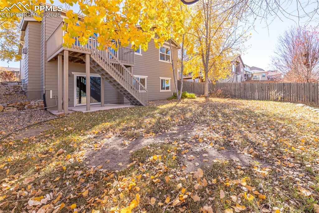 Image 34 of 41: Back of house featuring a patio area, a wooden deck, stairs, and a fenced b
