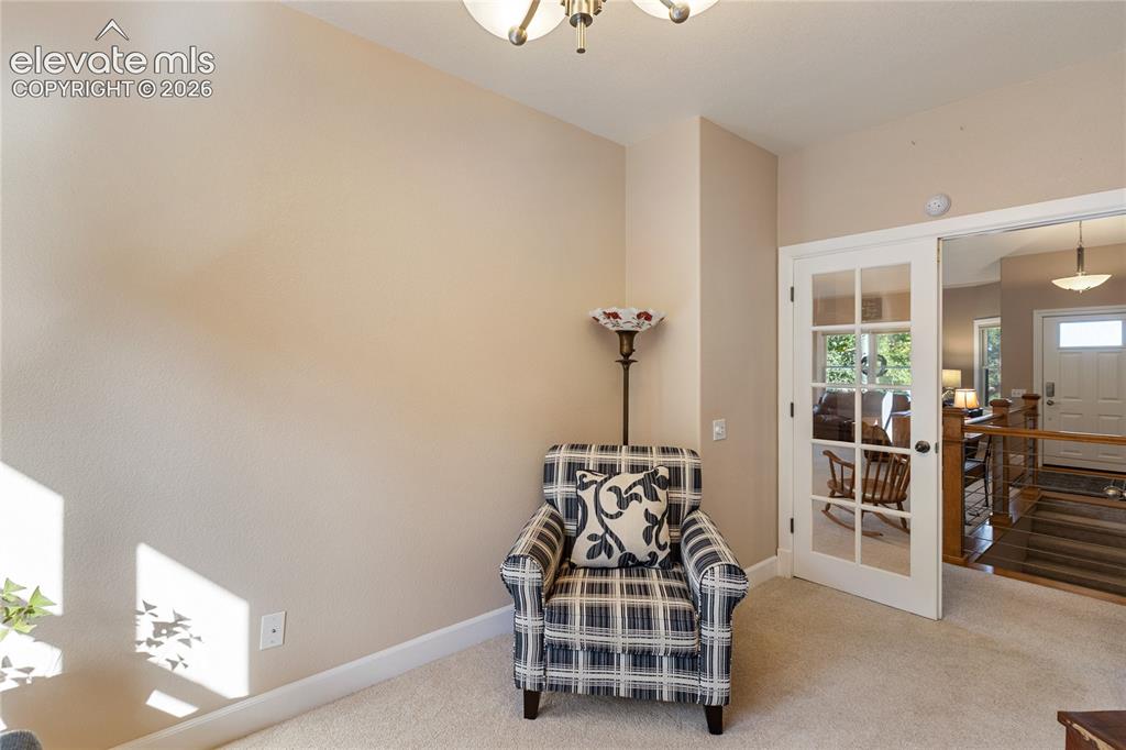 Image 15 of 38: Carpeted flooring, neutral wall tones, white trim, and a white French door