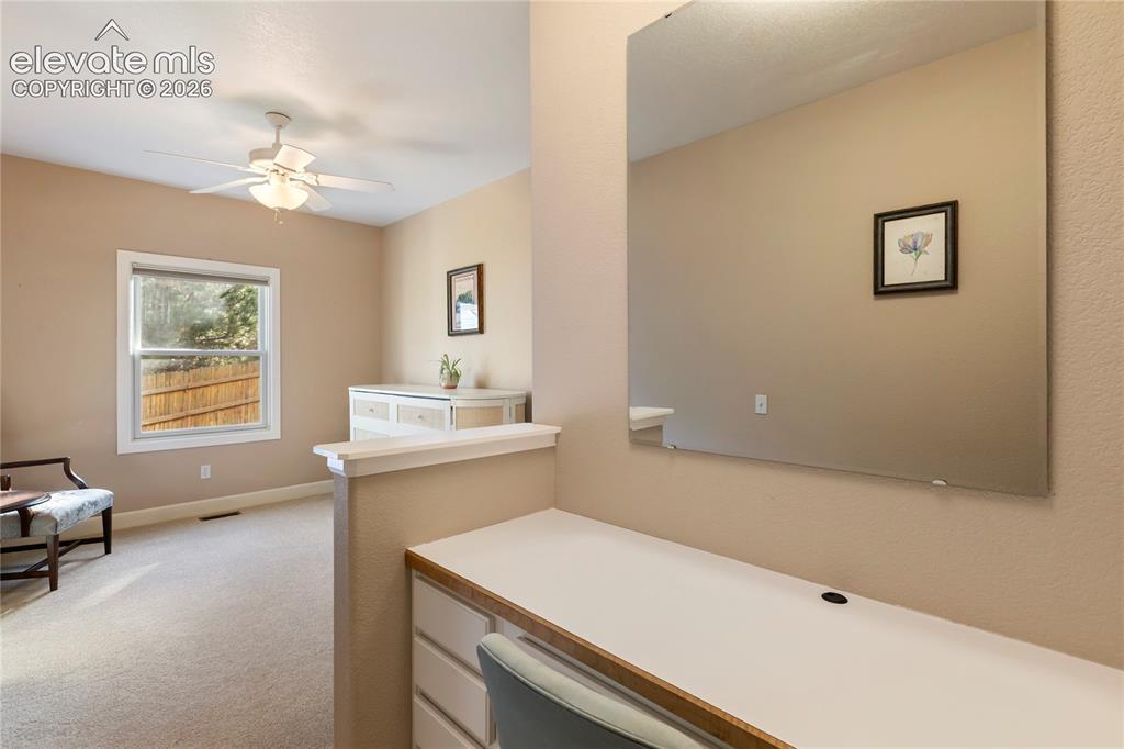 Image 19 of 38: Built-in desk with integrated storage and a large wall-mounted mirror
