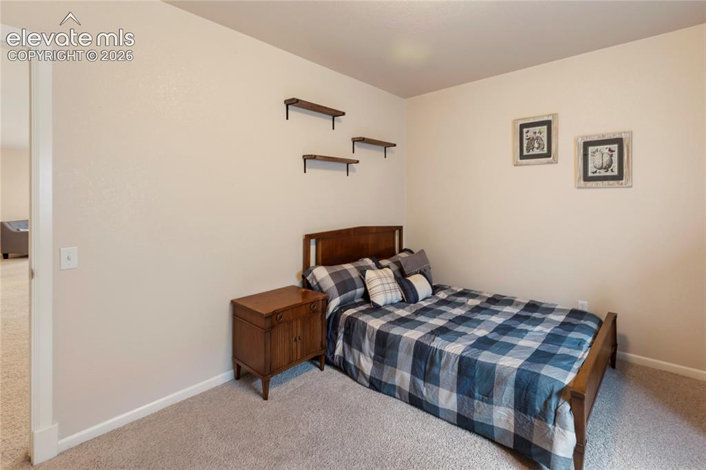 Image 26 of 38: Carpeted room featuring light-toned walls and a built-in wooden shelving un