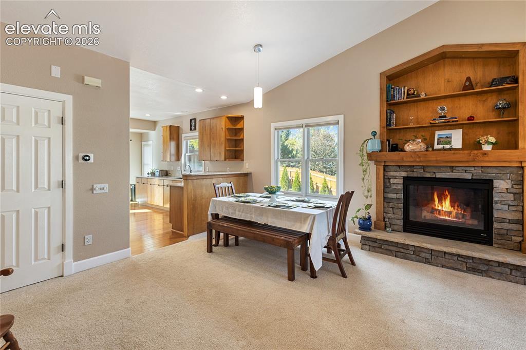 Image 31 of 38: Vaulted ceilings, a stone-surround fireplace with a wood mantle, built-in s