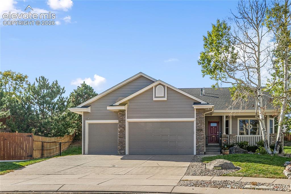 Image 38 of 38: Contemporary exterior with a two-car garage, stone accents, and covered fro