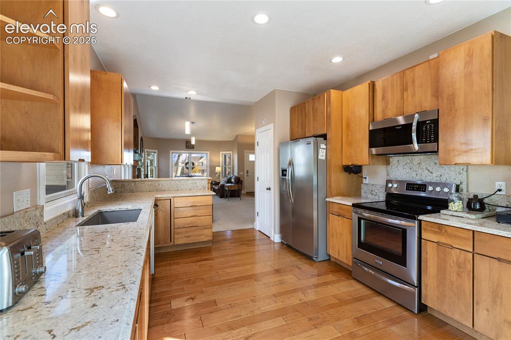 Image 5 of 38: Kitchen featuring wood-finish flooring, recessed lighting, stainless steel