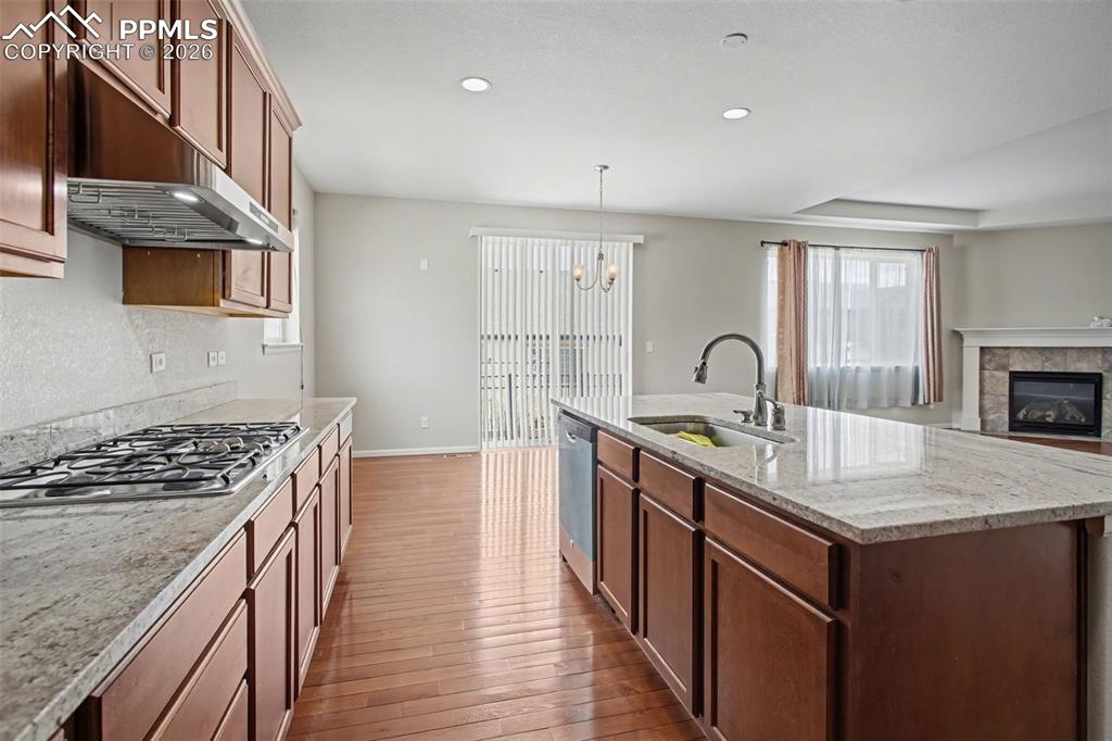 Image 14 of 40: Kitchen featuring light stone countertops, dark wood-type flooring, a tile 