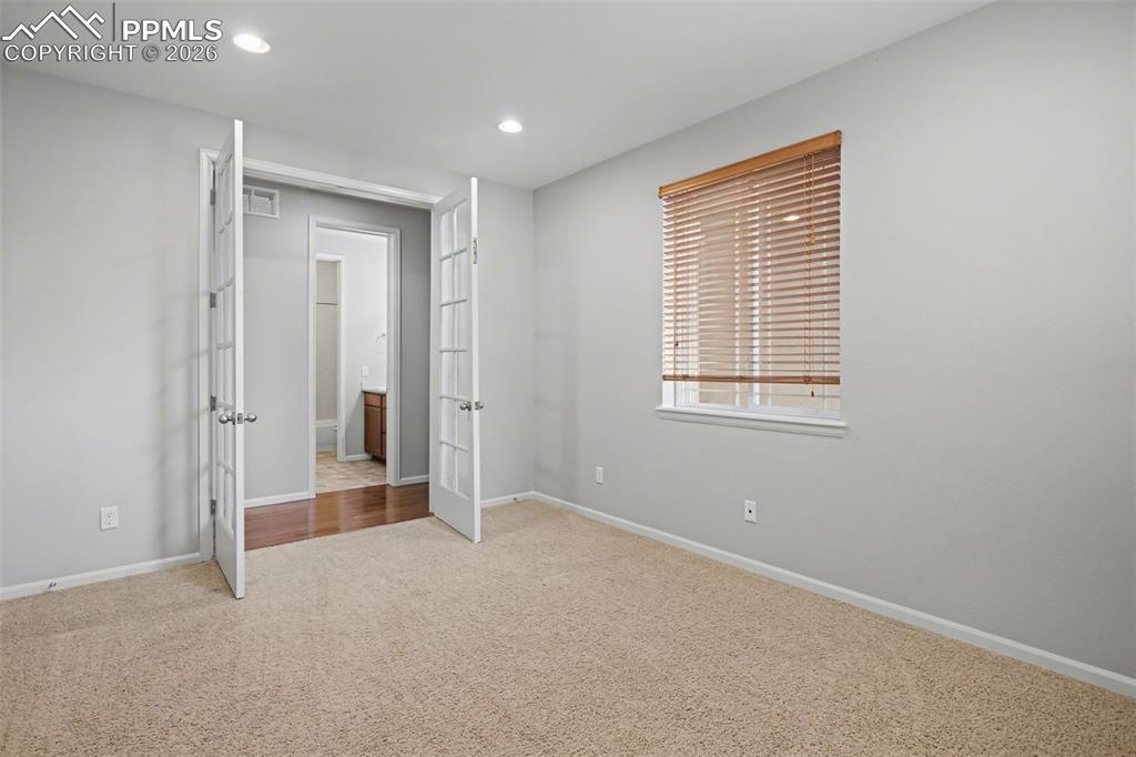 Image 18 of 40: Unfurnished bedroom with light carpet and recessed lighting