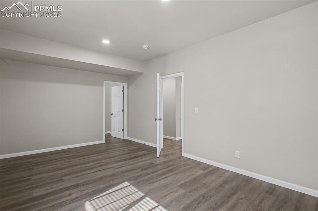 Image 31 of 40: Spare room with baseboards and dark wood finished floors
