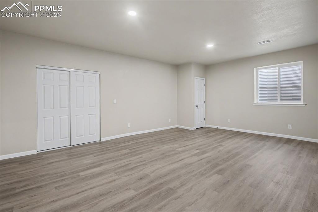 Image 33 of 40: Unfurnished bedroom with wood finished floors and a closet