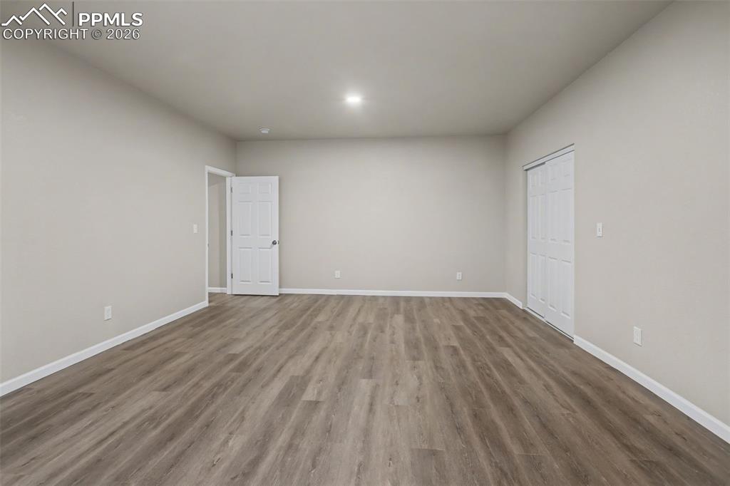 Image 34 of 40: Empty room featuring baseboards and dark wood-style floors