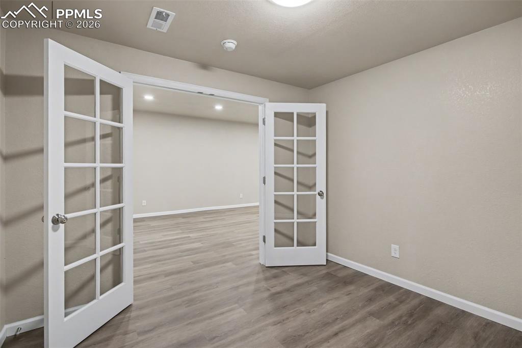 Image 35 of 40: Unfurnished room with french doors and dark wood finished floors
