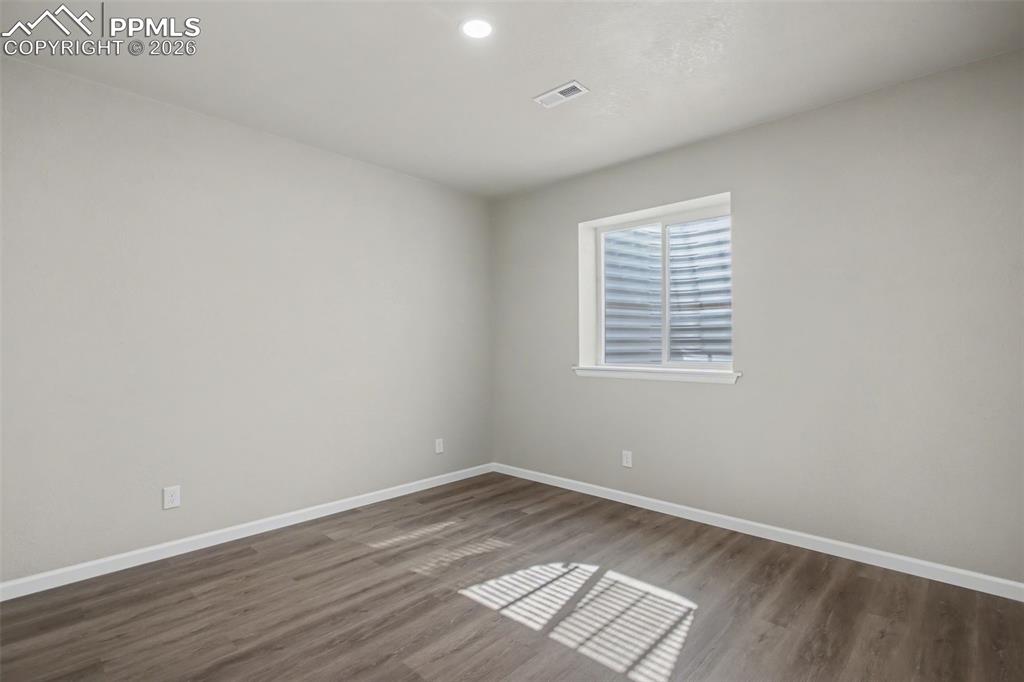 Image 37 of 40: Unfurnished room with dark wood-type flooring and recessed lighting